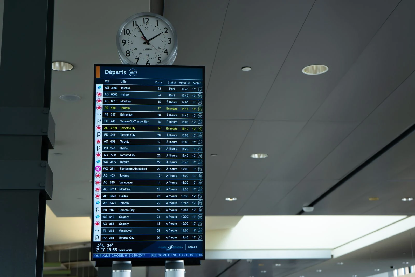 空港の時計と発着案内板が並んだイメージ