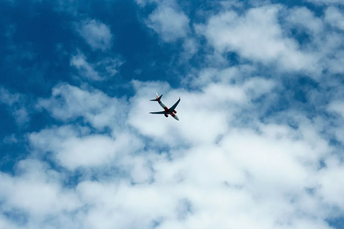 青空を飛ぶ飛行機のイメージ